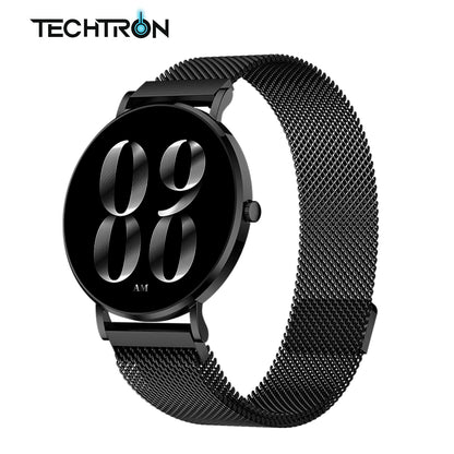 smart tech store Canada. premium tech accessories Canada. Techtron Aurafit AM28 Smart Watch. Gallery image 2. The watch is centered in the frame, showcasing a sleek, round design with a glossy black face displaying the time in large, stylized silver numbers. The mesh band is also black, featuring a textured pattern that adds depth. A small round button is visible on the right side of the watch, and the overall lighting is bright, highlighting the watch's reflective surfaces.