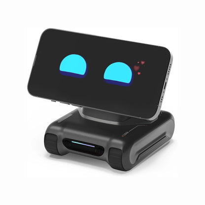 future tech gadgets Canada. smart tech store Canada. LOOI L01 AI Desk Companion Robot. Gallery image 2. A smartphone is positioned upright on a compact black charging dock, which has a smooth, matte finish. The phone's screen displays two blue semi-circles with hearts, suggesting a playful or affectionate theme. The dock features a small LED light strip at the front and has rounded edges, with rubberized grips on the sides for stability.