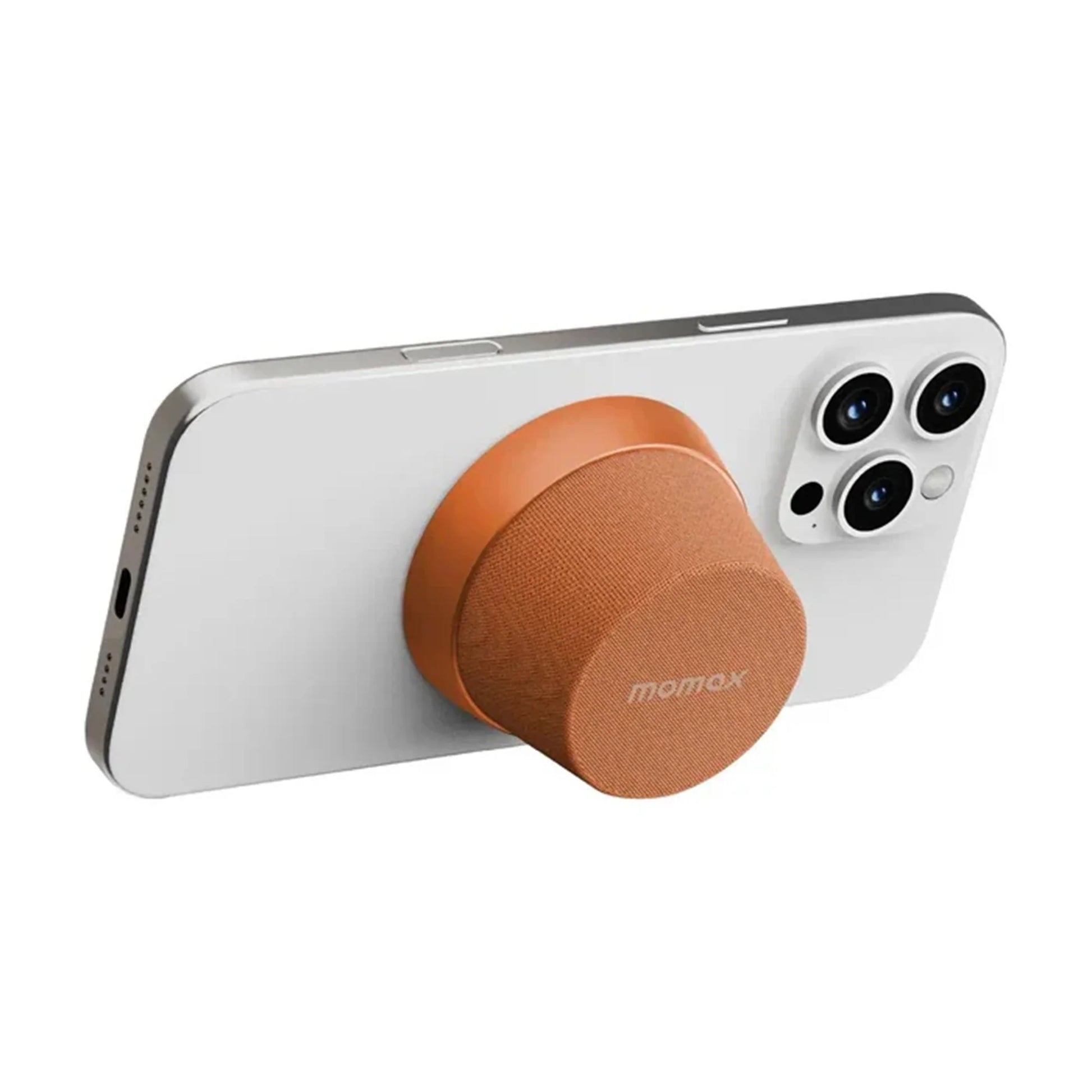 future tech gadgets Canada. premium tech accessories Canada. Momax 1-Vibe Go Magnetic Wireless Speaker. Gallery image 12. A smartphone is positioned at an angle, showcasing its sleek white back and three camera lenses on the upper right. Attached to the phone is a round, orange accessory with a textured fabric surface, likely a grip or stand. The background is a seamless white, emphasizing the product's clean design.