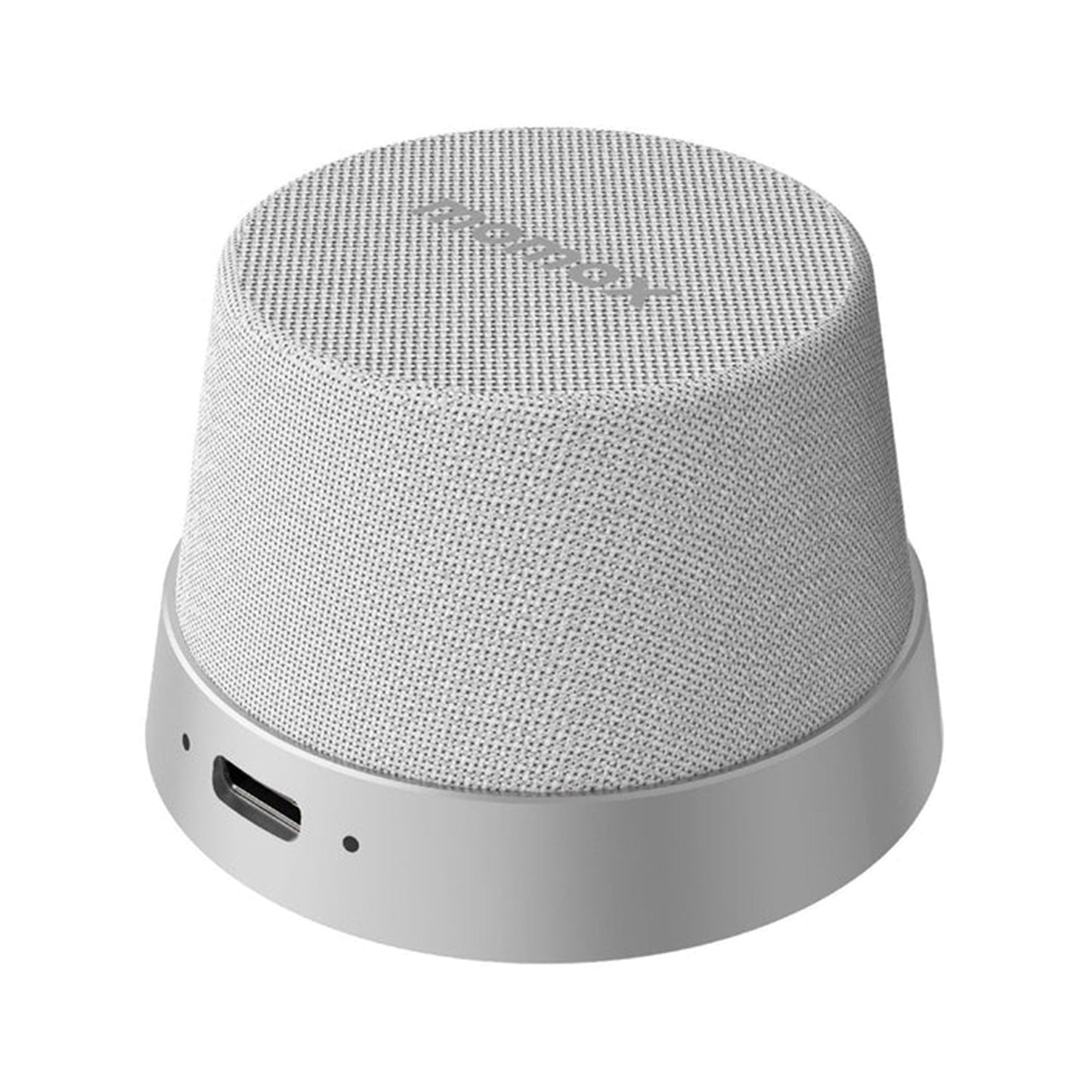 future tech gadgets Canada. premium tech accessories Canada. Momax 1-Vibe Go Magnetic Wireless Speaker. Gallery image 6. The speaker is positioned slightly off-center, showcasing its rounded, cylindrical shape. The exterior features a textured, light grey fabric covering, while the base is a smooth, matte silver. A USB-C port is visible on the side, along with a small status LED indicator. The background is a seamless white, enhancing the product's clean and modern aesthetic.