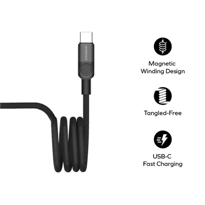 future tech gadgets Canada. smart tech store Canada. Momax Mag.Link 100W Usb-C To Usb-C Magnetic Cable 1M. Gallery image 8. A black USB-C charging cable is displayed prominently in the center of the frame, coiled neatly with a smooth texture. The cable features a sturdy connector with a button near the base, and the brand name "momax" is visible on the connector. The background is solid black, emphasizing the cable's design.