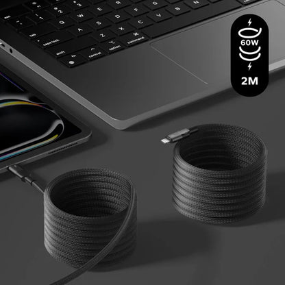 next gen electronics shop. buy electronics online Canada. Momax Mag.Link Usb-C To Lightning Magnetic Cable 2M. Gallery image 4. A black braided charging cable is coiled on a dark surface, with one end connected to a sleek laptop positioned at the top left of the frame. The laptop features a silver body and a black keyboard, partially visible. To the right, a second coiled section of the cable lies loose, showcasing its texture.