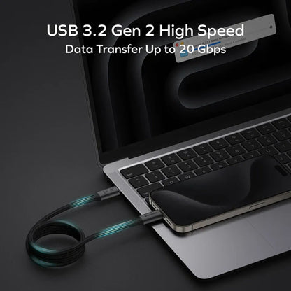 smart tech store Canada. next gen electronics shop. Momax Mag Link 100W USB-C to USB-C USB 3.2 Gen 2x2 Magnetic Cable 1M. Gallery image 2. A sleek black USB cable is prominently displayed, connecting a smartphone to a silver laptop. The cable features a textured surface and glowing blue-green accents near the ends. The laptop is partially open, revealing a dark keyboard and a screen displaying data transfer information. The background is a smooth black surface, enhancing the modern aesthetic.