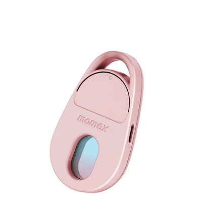 future tech gadgets Canada. smart tech store Canada. Momax Pinguard Camera Scanning Find My Locator. Gallery image 3. The product is a small, oval-shaped device in a soft pink color, positioned at a slight angle to the right in the frame. It features a glossy finish and a transparent window at the bottom, revealing a blue-tinted lens. The top section has a rounded cover with a small button, and there is a charging port visible on the side.