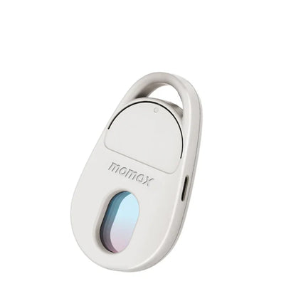 future tech gadgets Canada. smart tech store Canada. Momax Pinguard Camera Scanning Find My Locator. Gallery image 5. The product is a small, oval-shaped device in a light gray color, positioned at a slight angle against a plain white background. The front features a glossy, rounded lens with a subtle gradient of blue and purple, and the brand name "momax" is embossed in the center. A small, circular button is located above the lens, and a port is visible on the side.