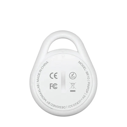 future tech gadgets Canada. smart tech store Canada. Momax Pinpop Lite Find My Tracker. Gallery image 5. The image shows a round, white device with a loop at the top, positioned centrally against a plain white background. The surface has a glossy finish, reflecting light softly. On the back, visible text includes "MODEL: BR10" and certification logos such as CE and FCC, arranged around a central slot. The overall design is minimalistic, emphasizing the device's compact size and simplicity.