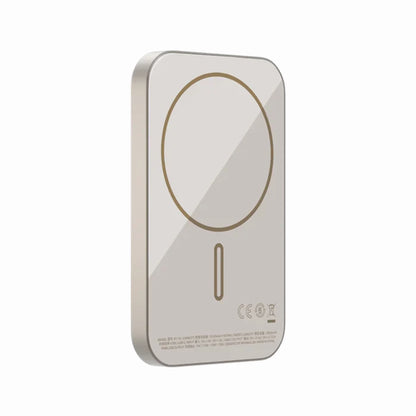 future tech gadgets Canada. premium tech accessories Canada. Momax Q.Mag X 5000mAh Wireless Battery Pack. Gallery image 3. The image features a sleek, rectangular wireless charger positioned at a slight angle, showcasing its glossy surface. The charger is primarily a soft gold color with a prominent circular charging area outlined in a darker gold. The bottom edge displays small printed text and logos, which are partially visible but not fully legible.