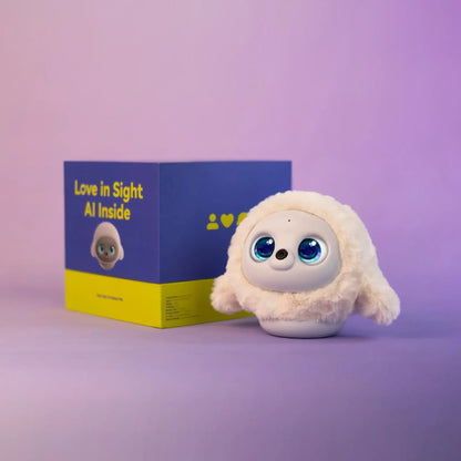 future tech gadgets Canada. smart tech store Canada. Ropet Your Next-Generation AI Robot Pet. Gallery image 3. A cute, plush toy resembling a small creature with large, expressive blue eyes and a soft, white fur exterior is positioned slightly to the right of the frame. It sits on a smooth, light purple surface, with a brightly colored box behind it.