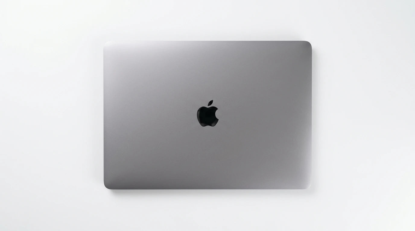 future tech gadgets Canada. smart tech store Canada. Certified Apple MacBook Pro 13″ (2020) A2251. Gallery image 4. The laptop is centered in the frame, showcasing its sleek, metallic gray exterior. The surface is smooth with a subtle brushed finish, and the iconic black Apple logo is prominently displayed in the center. The background is a seamless white, enhancing the product's minimalist design.