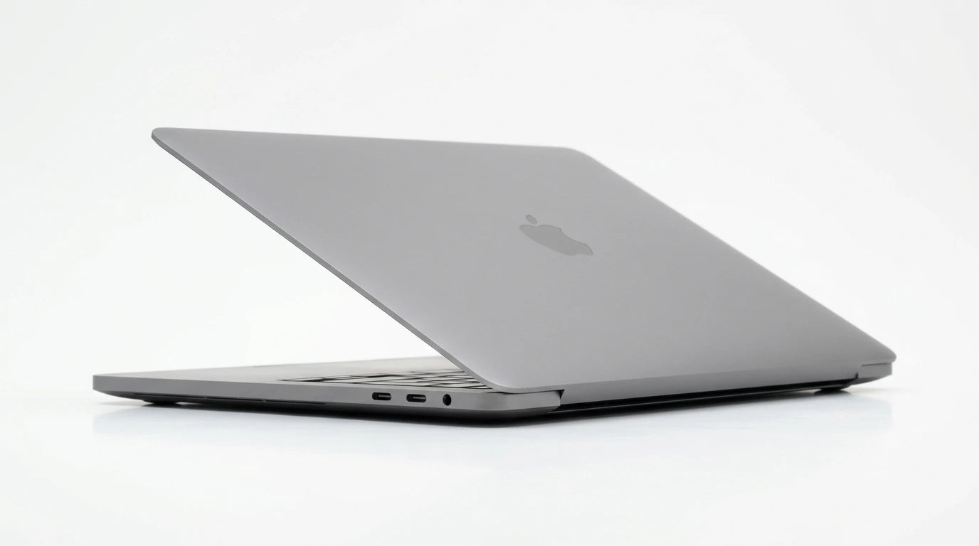 future tech gadgets Canada. smart tech store Canada. Certified Apple MacBook Pro 13″ (2020) A2251. Gallery image 6. The laptop is positioned at a slight angle, showcasing its sleek, metallic gray exterior. The Apple logo is visible on the lid, reflecting light softly. The device rests on a seamless white background, emphasizing its minimalist design. The left side features two USB-C ports and a headphone jack, clearly visible against the smooth surface.