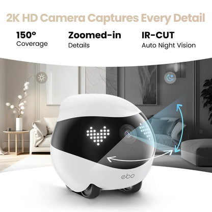 smart tech store Canada. premium tech accessories Canada. Enabot Ebo Air 2 Companion Robot. Gallery image 6. The image features a compact, rounded white robot with a glossy black band around its midsection, displaying a heart-shaped light pattern on its front. It is positioned slightly off-center, angled to the right, showcasing its camera lens and wheels. The background includes a modern living room setting with a light-colored sofa and a decorative plant, illuminated by soft, natural light.