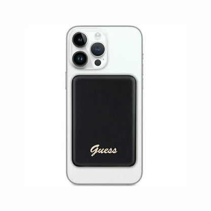 cutting edge electronics online Canada. premium tech accessories Canada. Guess Powerbank Magsafe Metal Script Logo 5000mAh 15W Black. Gallery image 4. A sleek white smartphone is centered in the frame, featuring a black Guess magnetic wallet attached to its back. The wallet has a smooth matte finish and displays the gold "Guess" logo prominently at the bottom.
