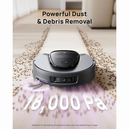 cutting edge electronics online Canada. smart tech store Canada. 3i Smart Robot Vacuum and Mop (G10 +). Gallery image 2. A sleek, round robotic vacuum is positioned in the center of the frame, angled slightly forward. It features a matte black top and a dark gray body, with visible buttons and sensors on the front. The vacuum is shown on a light-colored floor, with a trail of small debris, resembling coffee grounds, leading behind it.
