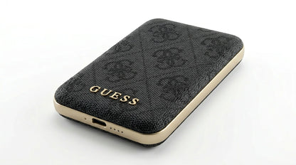 future tech gadgets Canada. premium tech accessories Canada. Guess BP MagSafe Case + PWB 5000mAh 4G. Gallery image 8. The image features a black phone case with a textured fabric surface, angled slightly to showcase its design. The case is adorned with a subtle pattern and the word "GUESS" prominently displayed in gold lettering along the bottom edge. The sides of the case are finished in a glossy gold trim, contrasting with the matte black texture.
