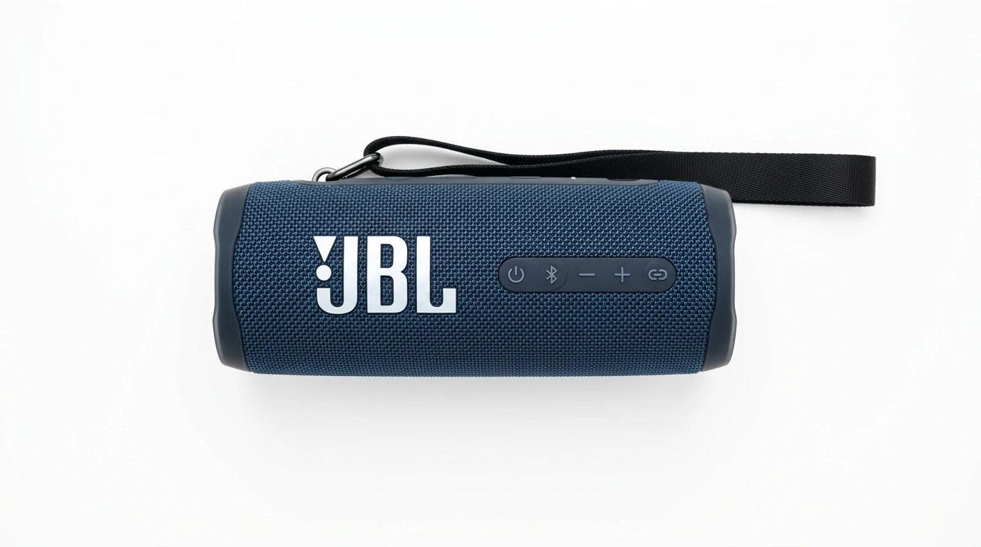 future tech gadgets Canada. smart tech store Canada. JBL Flip 7 Portable waterproof and drop-proof speaker. Gallery image 4. The image shows a portable Bluetooth speaker positioned centrally against a seamless white background. The speaker has a textured navy blue fabric exterior with a matte finish, and the prominent white "JBL" logo is displayed on the front. On the side, there are several buttons, including a power button and volume controls, all in a darker shade of blue.