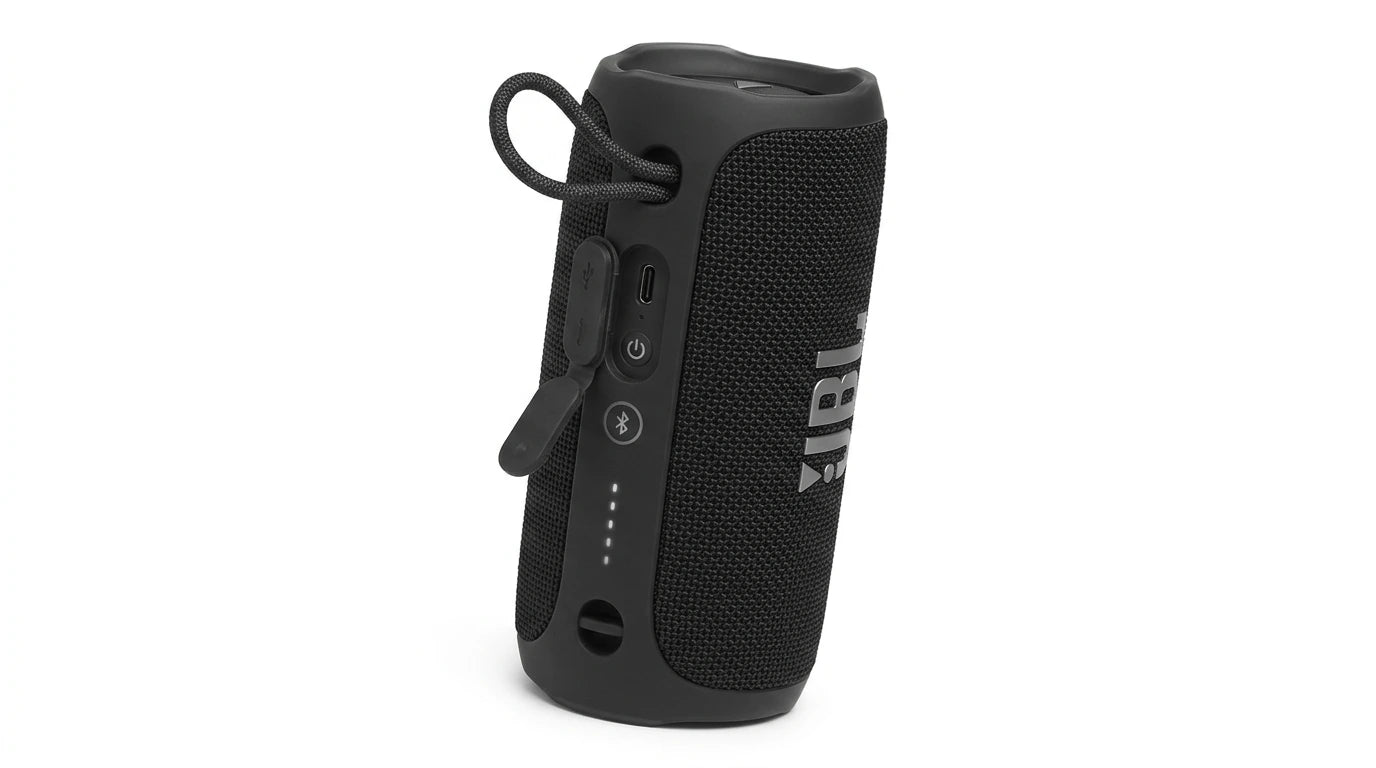 future tech gadgets Canada. smart tech store Canada. JBL Flip 7 Portable waterproof and drop-proof speaker. Gallery image 6. The portable speaker is positioned upright and slightly angled to the right, showcasing its cylindrical shape. It features a textured black fabric exterior with a glossy top and a prominent white JBL logo on the front. On the side, there are several buttons, including a power button and Bluetooth pairing, along with a protective flap covering a USB-C port.
