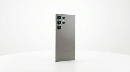 smart tech store Canada. next gen electronics shop. Premium Samsung Galaxy S24 Ultra. Gallery image 10. The smartphone is positioned at a slight angle, showcasing its sleek, matte silver back. It is centered against a seamless white background, which enhances its modern design. The camera module features three circular lenses, prominently displayed on the upper left side, with a small flash nearby. The Samsung logo is visible near the bottom of the device.