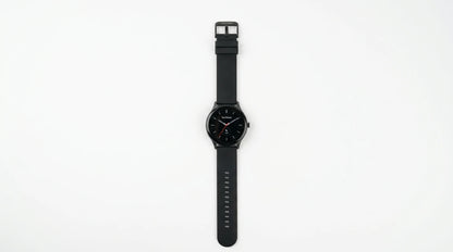 smart tech store Canada. premium tech accessories Canada. Techtron Aurafit AM28 Smart Watch. Gallery image 4. The watch is centered in the frame, displayed horizontally against a seamless white background. It features a round black face with silver hour markers and a prominent red second hand. The strap is matte black rubber with a series of small notches for adjustment. The watch has a sleek, modern design, and the brand name "Techtron" is visible at the top of the watch face.