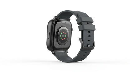 smart tech store Canada. premium tech accessories Canada. Techtron Aurafit AM28 Smart Watch. Gallery image 8. The image shows a black smartwatch positioned at a slight angle, revealing its back. The watch features a smooth, glossy surface with a circular sensor area that includes multiple colored lights—red and green—arranged in a grid pattern. The strap is a textured dark gray rubber, secured with a metal buckle, and has several adjustment holes visible.