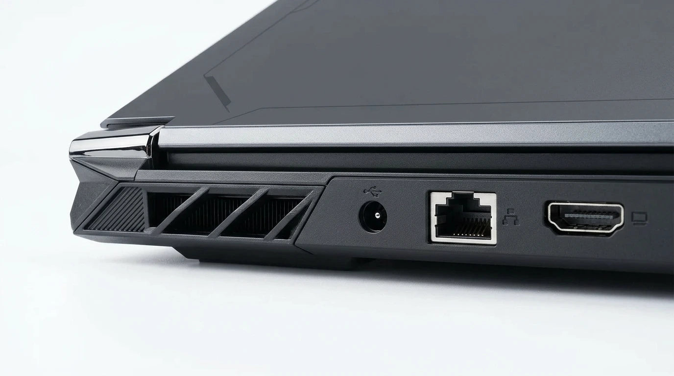 future tech gadgets Canada. smart tech store Canada. ThundeRobot R16 i9 Gaming Laptop. Gallery image 9. The image shows a close-up view of the left side of a laptop, angled slightly to reveal various ports and vents. The surface is a smooth, light grey, providing a clean backdrop. The laptop's body is predominantly matte black with glossy accents, particularly around the edges. Visible ports include a USB port, a power input, an Ethernet port, and an HDMI port, all neatly arranged.